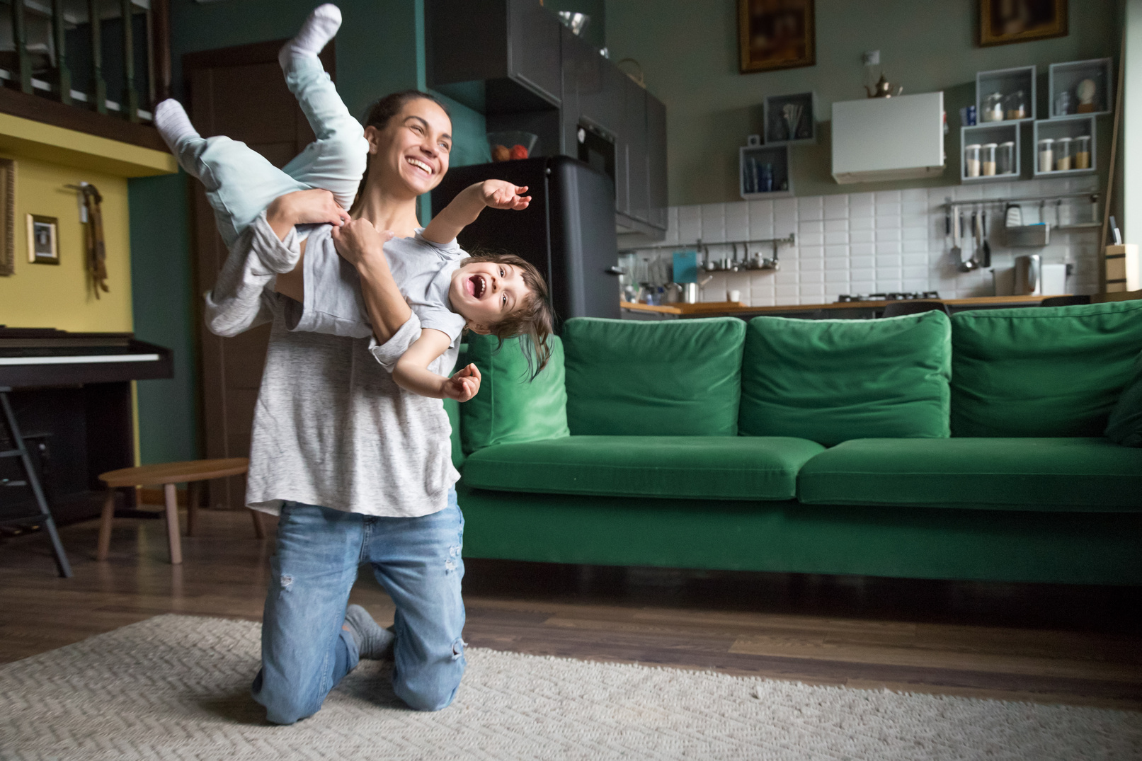 Happy mom or babysitter playing with kid girl at home